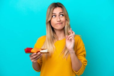 Mavi arka planda saşimi tutan genç Uruguaylı kadın şans diliyor.