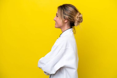 Uruguaylı şef kadın sarı arka planda yalıtılmış.