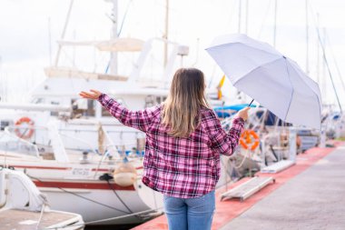 Açık havada şemsiye tutan genç ve güzel Romen kadın