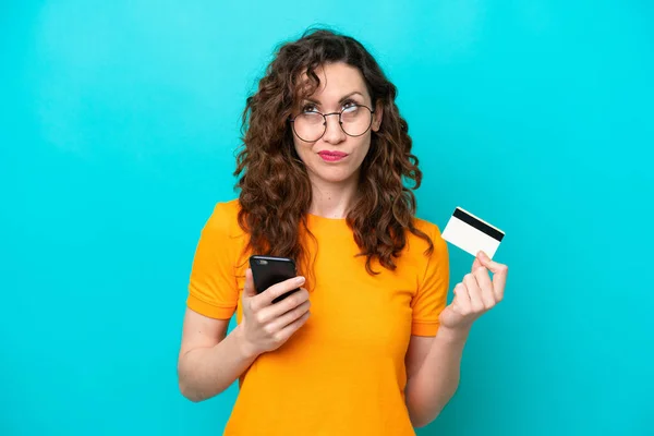 Jonge Blanke Vrouw Geïsoleerd Blauwe Achtergrond Kopen Met Mobiele Telefoon — Stockfoto