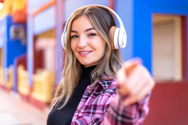 Молодая Красивая Румынская Женщина Открытом Воздухе Слушает Музыку Указывает Фронт — стоковое фото
