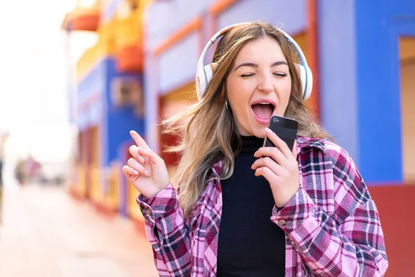 Νεαρή Όμορφη Ρουμάνα Εξωτερικούς Χώρους Ακούει Μουσική Κινητό Και Τραγουδάει — Φωτογραφία Αρχείου