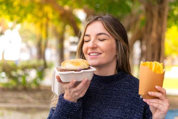 Młoda Ładna Rumuńska Kobieta Trzyma Hamburgera Frytki Świeżym Powietrzu — Zdjęcie stockowe