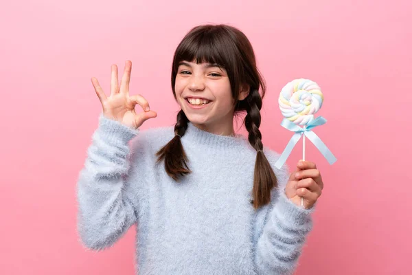 stock image Little caucasian girl holding a lollipop showing ok sign with fingers