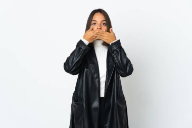 Beyaz arka planda izole edilmiş genç Latin kadın elleriyle ağzını kapatıyor.