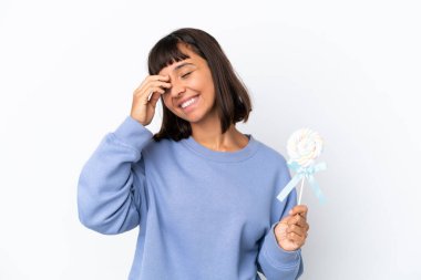 Young mixed race woman holding a lollipop isolated on white background smiling a lot