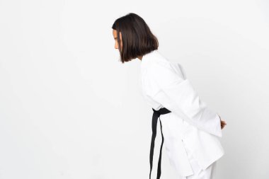 Beyaz arka planda karate yapan ve selam veren genç Latin kadın.