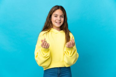 Küçük kız soyutlanmış mavi arka planda para hareketi yapıyor.