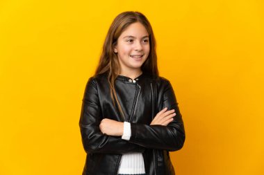 İzole edilmiş sarı arka plan üzerinde çocuk yana bakıyor ve gülümsüyor