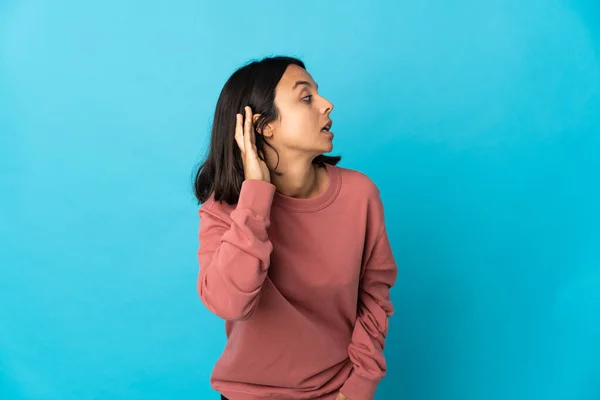 Junge Lateinische Frau Isoliert Auf Blauem Hintergrund Hört Etwas Indem — Stockfoto