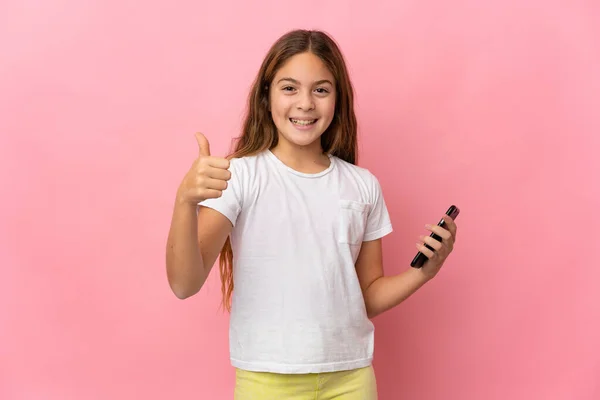 Criança Sobre Fundo Rosa Isolado Usando Telefone Celular Fazer Polegares — Fotografia de Stock