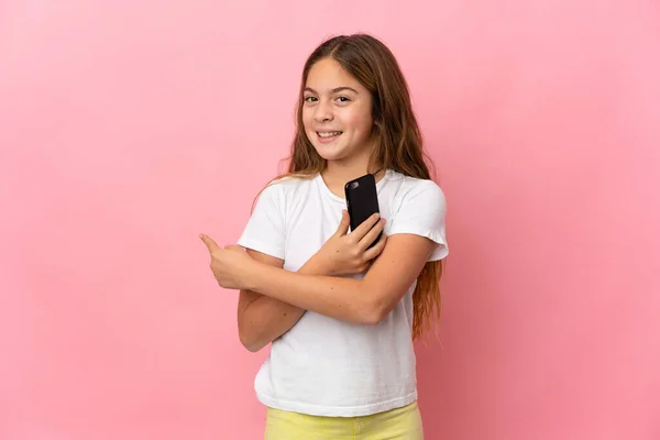 Criança Sobre Fundo Rosa Isolado Usando Telefone Celular Apontando Para — Fotografia de Stock
