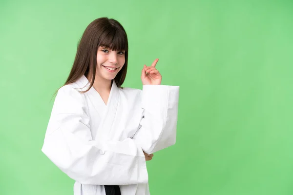 Little Caucasian Girl Doing Karate Isolated Background Pointing Finger Side — Stock Photo, Image