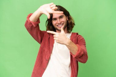 Tecrit edilmiş, odaklanmış yüzü olan genç yakışıklı bir adam. Çerçeve sembolü