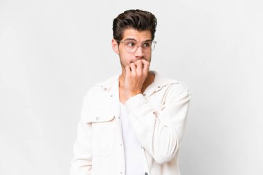 Soyutlanmış beyaz arka planda genç, yakışıklı, beyaz bir adam gergin ve korkmuş.