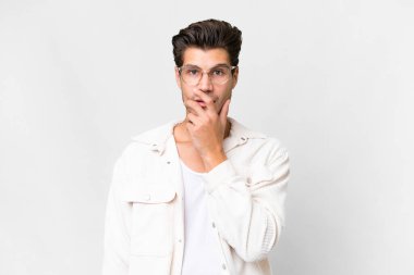 Beyaz arka planda yaşayan yakışıklı beyaz adam sağa bakarken şaşırdı ve şok oldu.