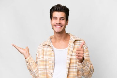 İzole edilmiş beyaz arka plan üzerinde yakışıklı beyaz bir adam fotokopi çekerken avucunda hayali bir tabaka tutuyor.