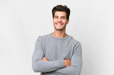 Young handsome caucasian man over isolated white background keeping the arms crossed in frontal position