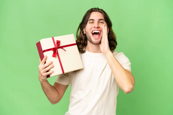 Young Handsome Man Holding Gift Isolated Background Shouting Mouth Wide — Stock Photo, Image