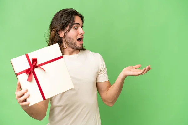Young Handsome Man Holding Gift Isolated Background Surprise Facial Expression — Stock Photo, Image