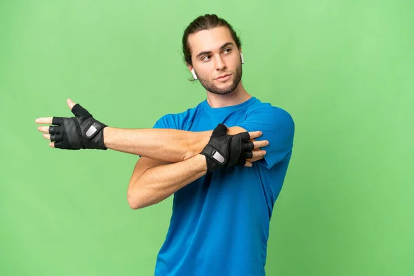 Ung Stilig Man Isolerad Grön Krom Bakgrund Stretching Arm — Stockfoto