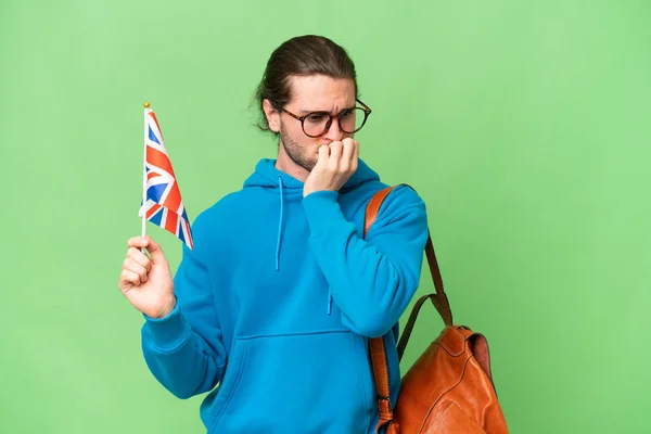 年轻英俊男子举着英国国旗 背景偏僻 令人怀疑 — 图库照片