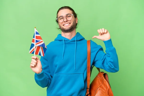 年轻英俊男子举着英国国旗 背景偏僻 感到自豪和满足 — 图库照片