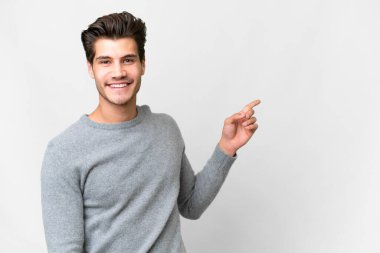 Young handsome caucasian man over isolated white background pointing finger to the side