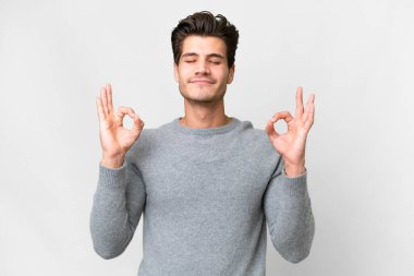 Zen pozisyonunda beyaz tenli, yakışıklı, beyaz bir adam.