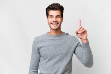 Young handsome caucasian man over isolated white background showing and lifting a finger in sign of the best