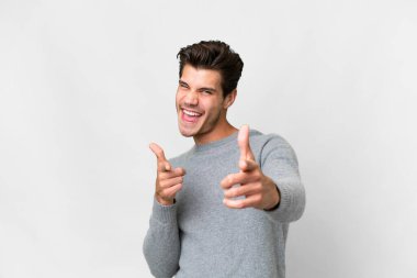 İzole edilmiş beyaz arka planı olan yakışıklı beyaz bir adam öne bakıyor ve gülümsüyor.