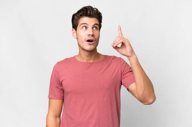 İzole edilmiş beyaz bir geçmişi olan yakışıklı beyaz bir adam çözümü bulmak için parmağını kaldırıyor.