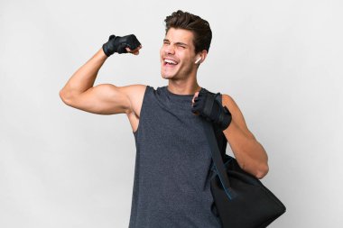 Spor çantalı beyaz tenli genç beyaz adam güçlü bir jest yapıyor.