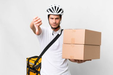 Delivery man wearing a helmet bike over isolated white background showing thumb down with negative expression