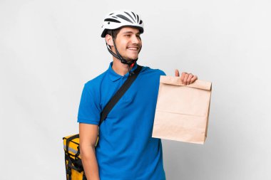 Kafkasyalı genç bir adam arka planda izole edilmiş arka planda bir paket yiyecek alıyor.