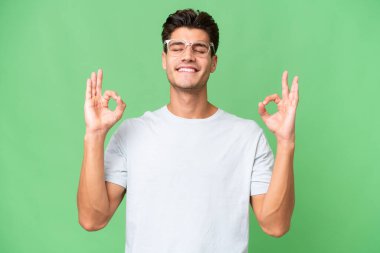 Zen pozunda soyutlanmış beyaz, yakışıklı genç bir adam.