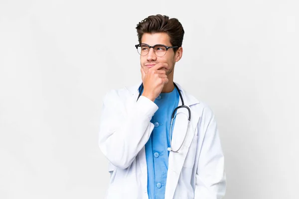 年轻的医生 在孤独的白人背景上 有着疑惑和困惑的面部表情 — 图库照片