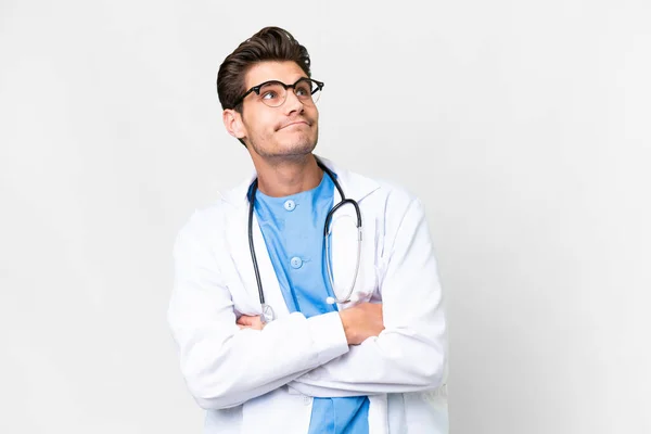 Junger Arzt Vor Isoliertem Weißen Hintergrund Macht Zweifel Geste Beim — Stockfoto