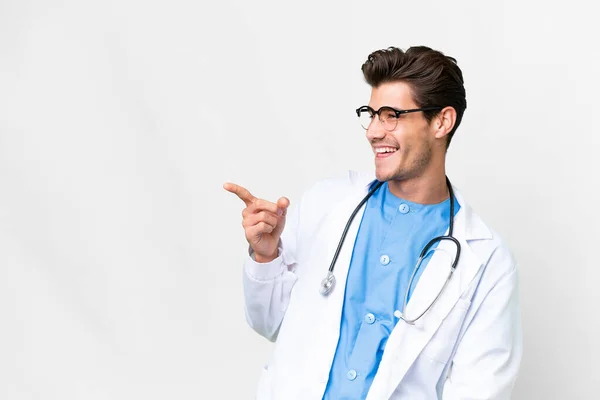 Junger Arzt Vor Isoliertem Weißen Hintergrund Zeigt Mit Dem Finger — Stockfoto