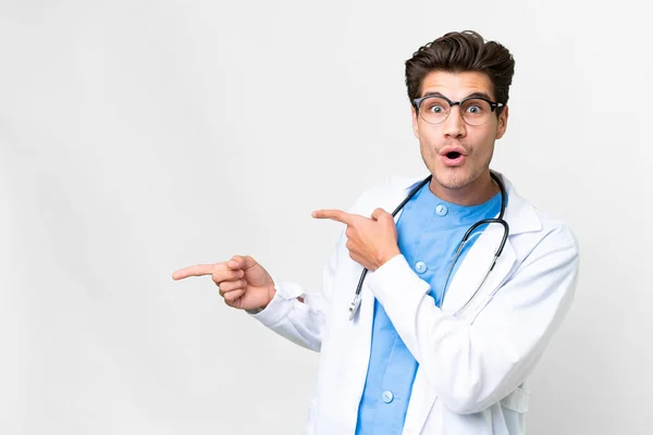 Young Doctor Man Isolated White Background Surprised Pointing Side — Stock fotografie
