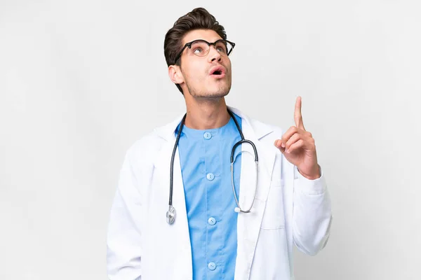 Mladý Lékař Muž Přes Izolované Bílé Pozadí Ukazuje Nahoru Překvapen — Stock fotografie