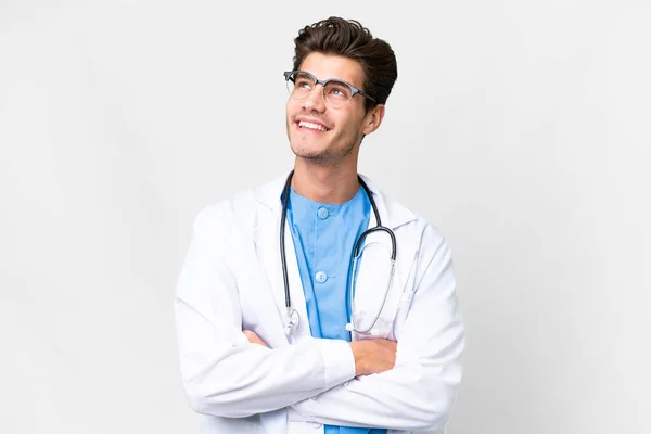Молодий Лікар Над Ізольованим Білим Тлом Дивлячись Вгору Посміхаючись — стокове фото