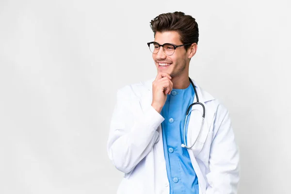 Junger Arzt Vor Isoliertem Weißen Hintergrund Der Zur Seite Schaut — Stockfoto