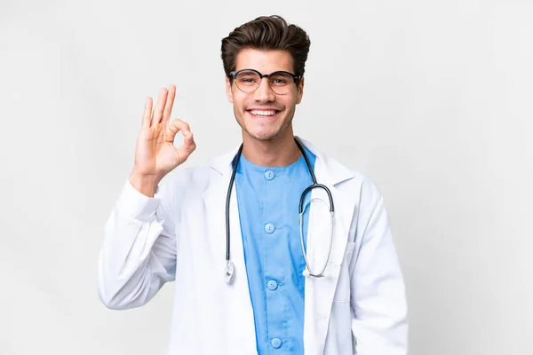 Młody Lekarz Człowiek Odizolowanym Białym Tle Pokazuje Znak Palcami — Zdjęcie stockowe