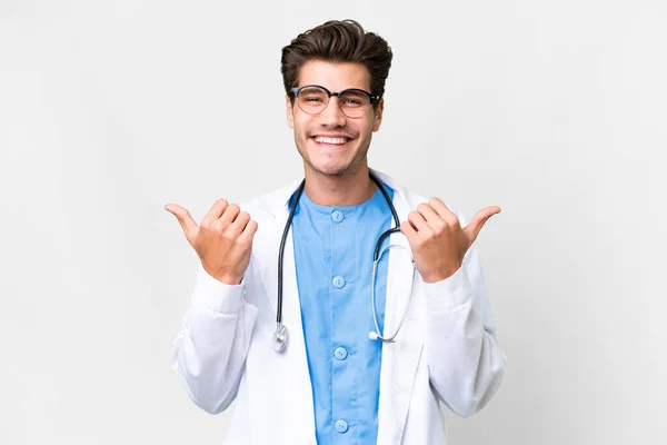 年轻的医生 有着孤独的白种人背景 竖起大拇指 微笑着 — 图库照片