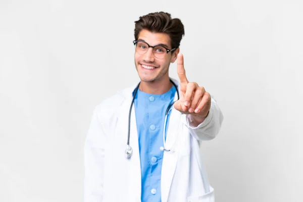 Joven Médico Sobre Fondo Blanco Aislado Mostrando Levantando Dedo — Foto de Stock