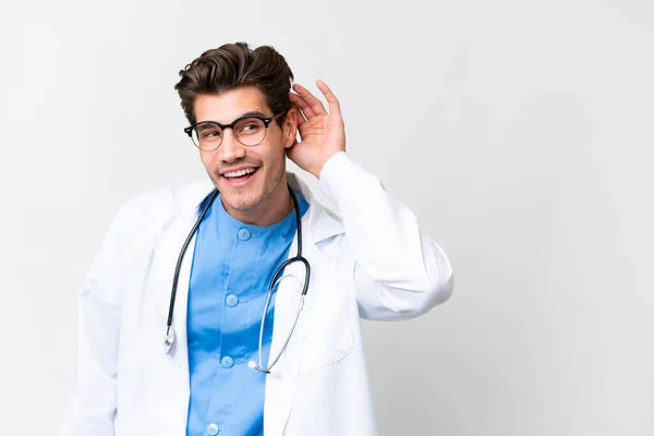 Junger Arzt Vor Isoliertem Weißen Hintergrund Hört Etwas Indem Die — Stockfoto