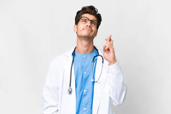 Mladý Lékař Muž Přes Izolované Bílé Pozadí Prsty Kříž Přeje — Stock fotografie