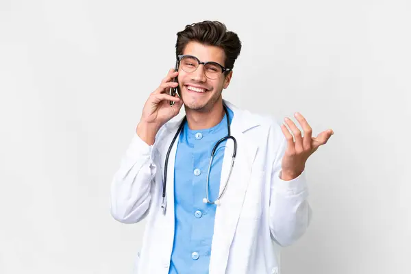 Młody Lekarz Białym Tle Rozmawiający Kimś Przez Telefon Komórkowy — Zdjęcie stockowe