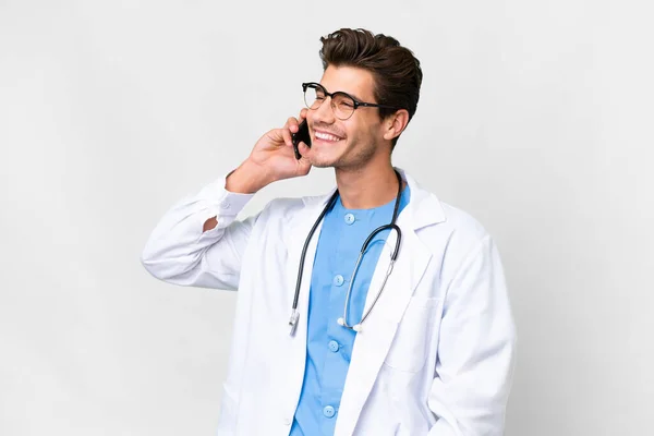 Młody Lekarz Nad Odizolowanym Białym Tle Prowadzenie Rozmowy Telefonu Komórkowego — Zdjęcie stockowe
